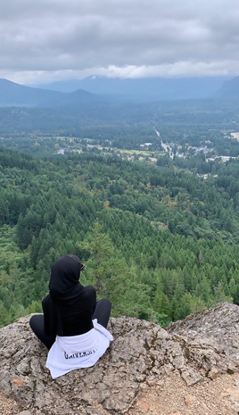 Aisha Burka looks out over a forested mountain