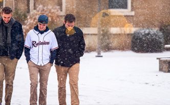 Students walk across campus through the snow