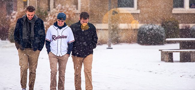 Students walk across campus through the snow